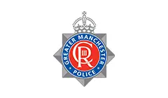 Logotipo oficial de la Policía de Gran Mánchester, que muestra una insignia en forma de estrella gris plateada con un emblema circular rojo y una corona.